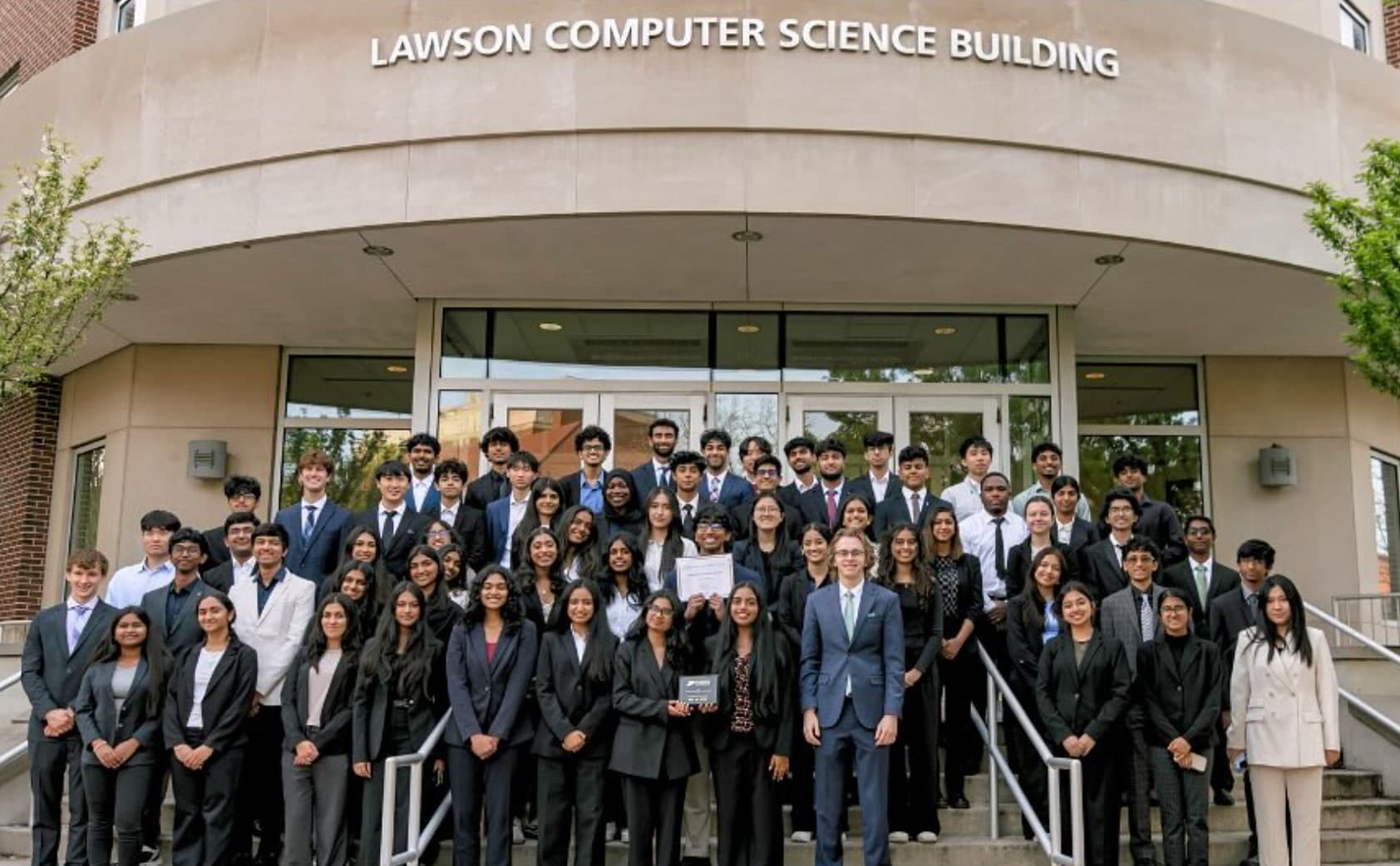 Hack the Future members in business attire on the steps of the Lawson Computer Science Building